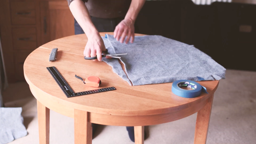 Cutting pieces of smoke-grey van carpet on a table