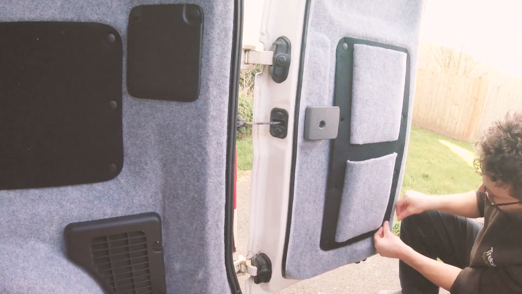 Reattaching the small back door panel to the van