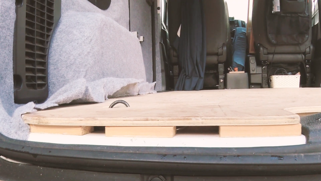 A section of the back edge of the van floor, showing wooden supporting blocks