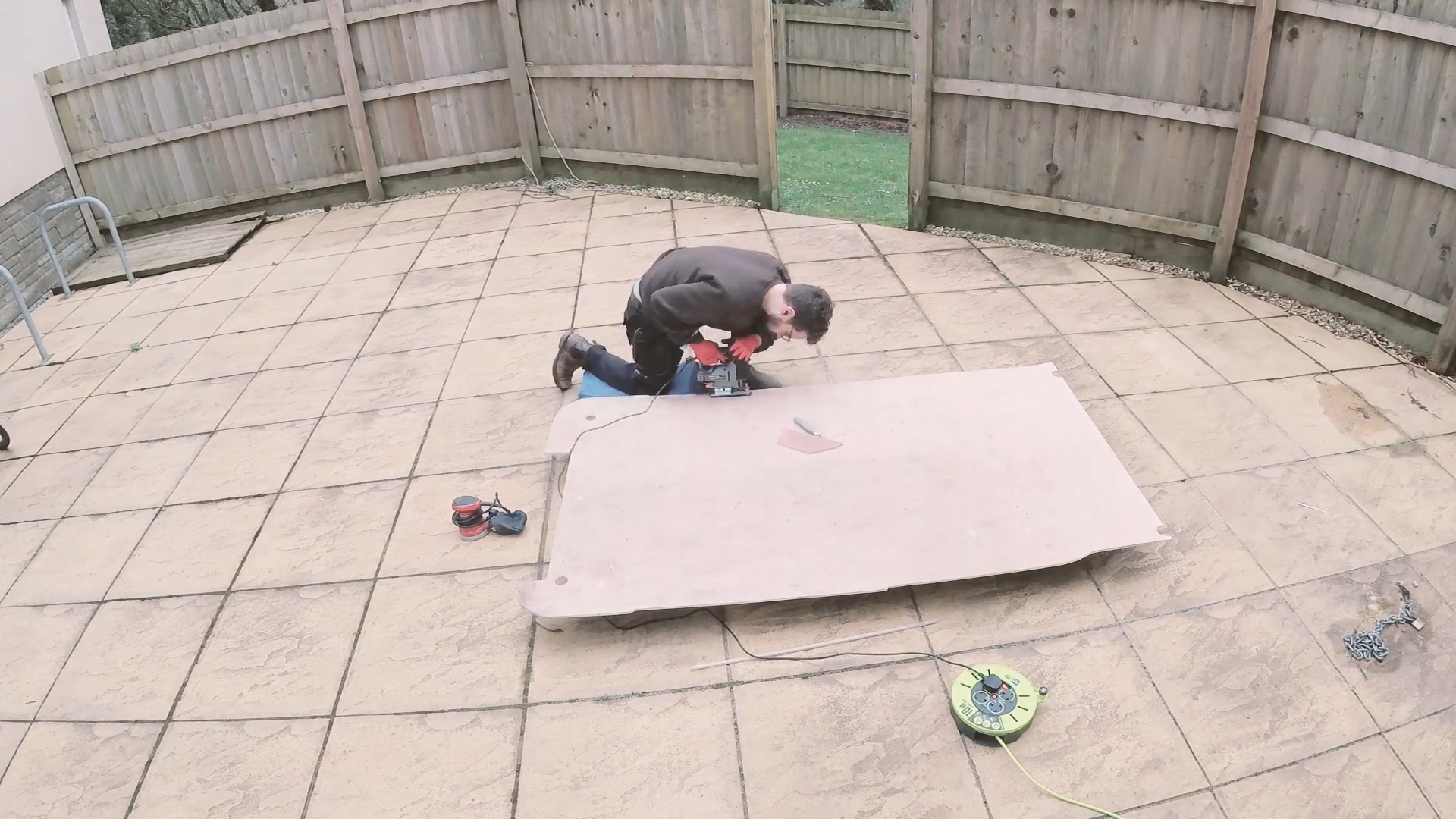 Cutting the plywood floor down to size with a jigsaw power tool